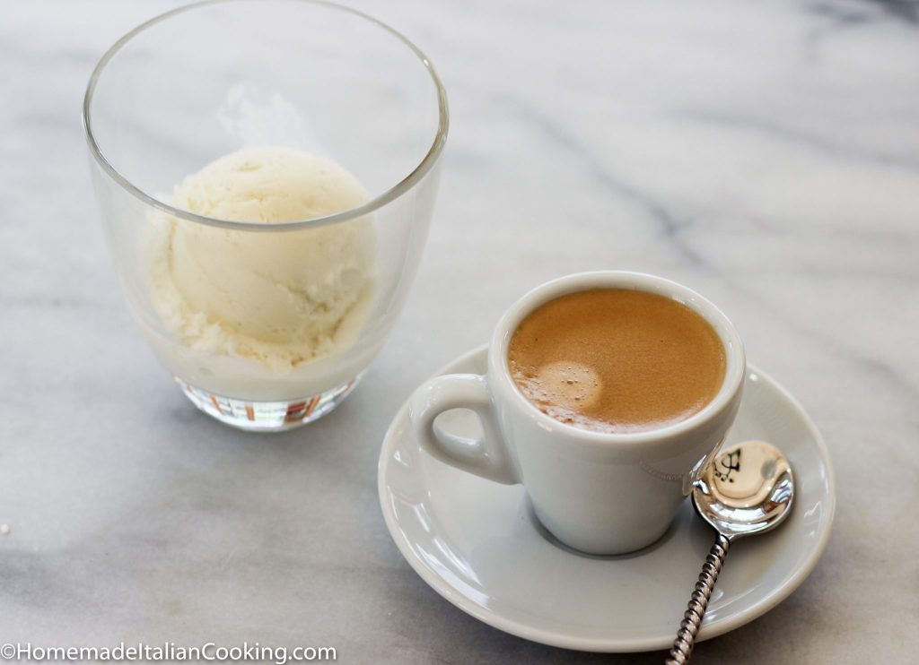 image of an espresso in a white cup with a glass of vanilla ice cream beside it on a white marble table